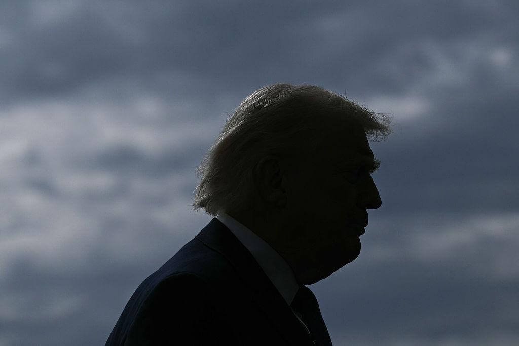Silhouette de Trump en contre-jour sur fond de ciel nuageux sombre