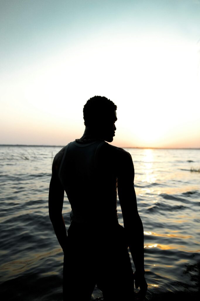 Silhouette face à l’océan au coucher du soleil, illustrant la réflexion sur l’avenir institutionnel de la Guadeloupe