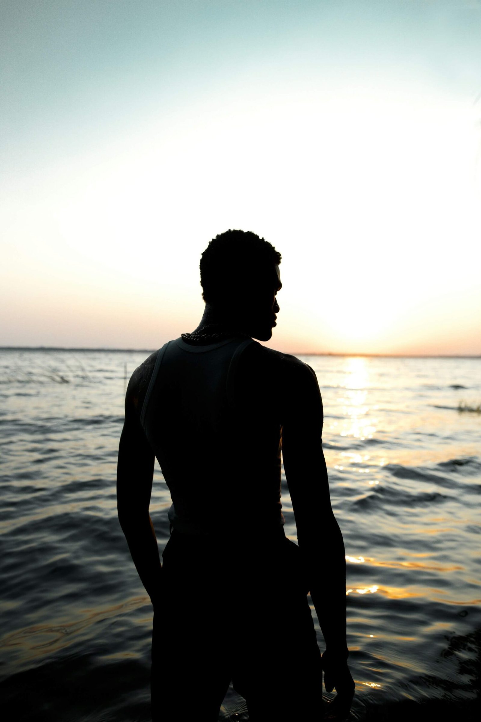 Silhouette face à l’océan au coucher du soleil, illustrant la réflexion sur l’avenir institutionnel de la Guadeloupe